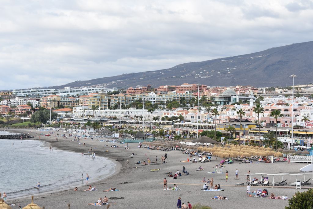 Relaxing beach scene at Playa de Fañabé in Costa Adeje, Tenerife, showcasing vibrant coastal life.
